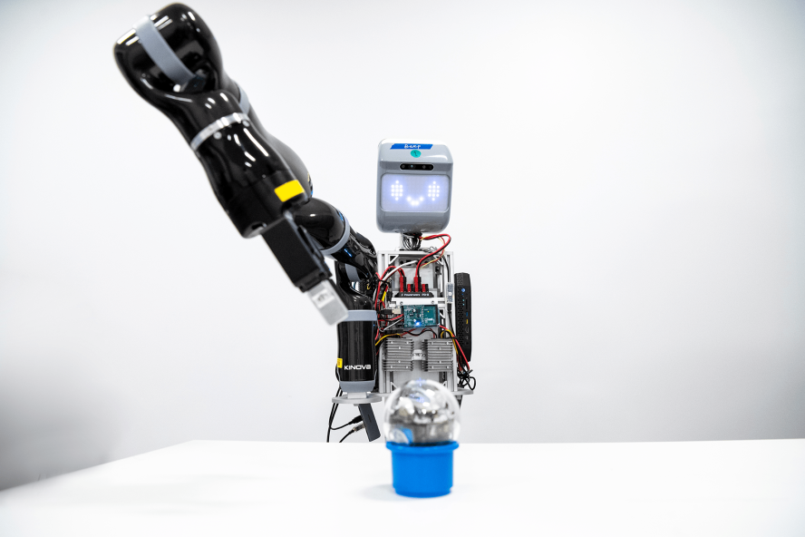 A robot extends its arm to pick up an object.