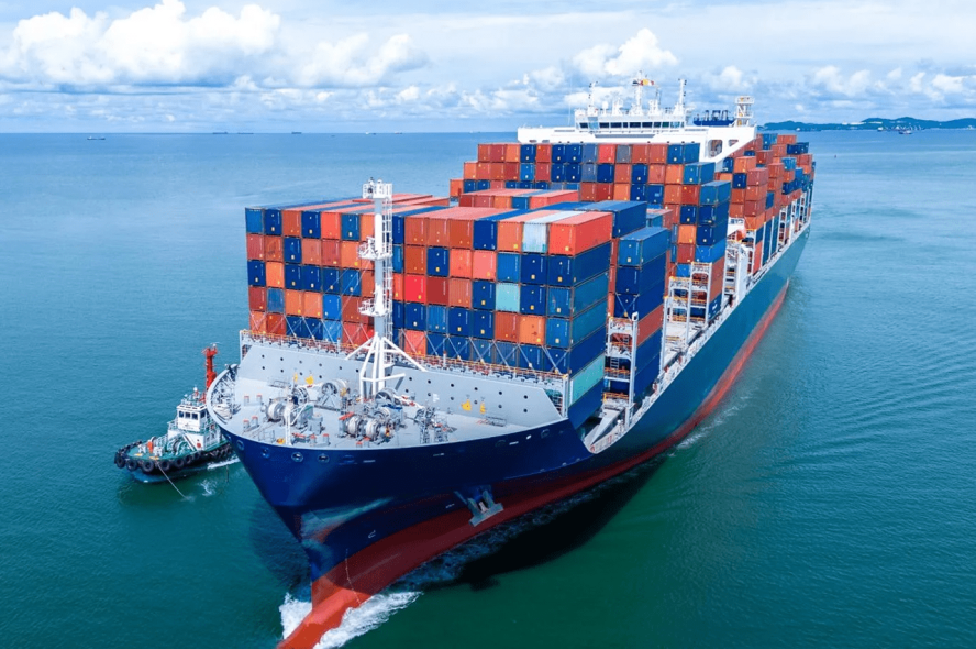 A stern of a cargo ship loaded with shipping containers stacking high.