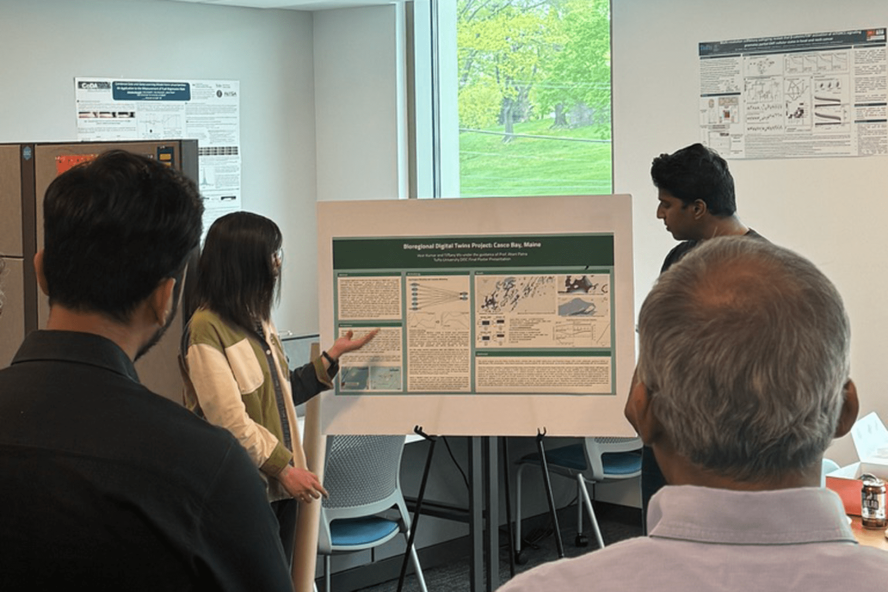 Students present their research poster to an audience at Tufts University.